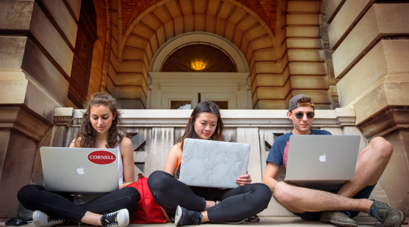 three students with laptops