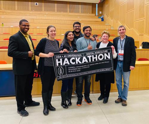 Cornell Digital Ag Hackathon winners and faculty members holding a banner.